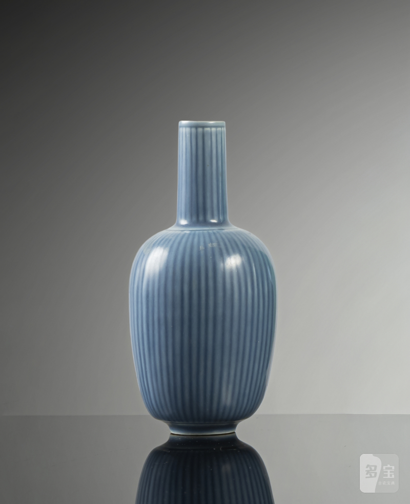 A blue glazed narrow neck porcelain vase with ribbed wall and neck